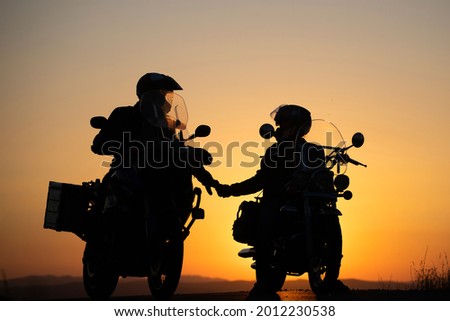 Motorcycle couple in sunset with classic motorcycle