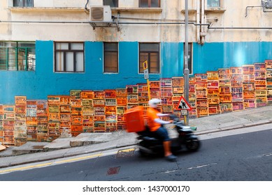 A motorcycle courier passing by the famous Graham Street Wall Mural, a colorful street art and a popular Instagram check-in spot in Central District, Hong Kong, China, Asia