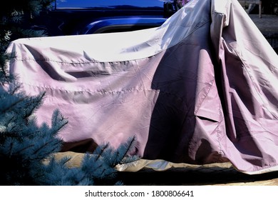 Motorcycle Covered With Tarp In Driveway