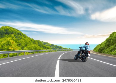 motorcycle drive on the europe coastal road landscape in summer. Riding a motorcycle is freedom. motorbike driver is speeding along the travel road. Sea view on highway on the Mediterranean beach