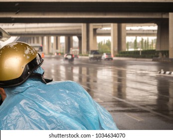 Motorcycle Driver Hiding From Rain Under Bridge On A Rainy Day