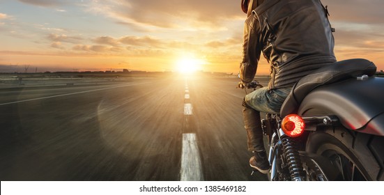 Motorcycle Driver Riding Alone On Asphalt Motorway. Outdoor Photography. Travel And Sport, Speed And Freedom Concept