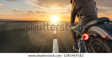 Motorcycle driver riding alone on asphalt motorway. Outdoor photography. Travel and sport, speed and freedom concept