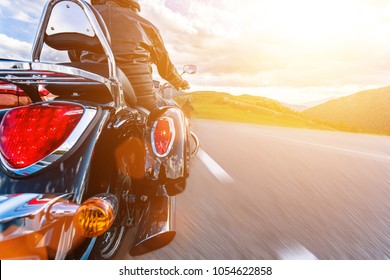 Motorcycle driver riding in Alpine highway, Nockalmstrasse, Austria, central Europe. Nontraditional back side view. - Shutterstock ID 1054622858