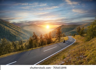 Motorcycle driver riding in Alpine highway,  Nockalmstrasse, Austria, Europe. Outdoor photography, mountain landscape. Travel and sport photography. Speed and freedom concept - Powered by Shutterstock
