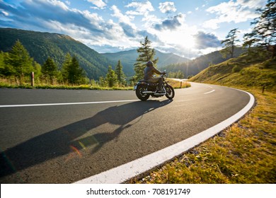 Motorcycle driver riding in Alpine highway, Nockalmstrasse, Austria, central Europe.