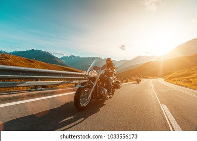 Motorcycle driver riding japanese high power cruiser in Alpine highway on famous Hochalpenstrasse, Austria, central Europe.