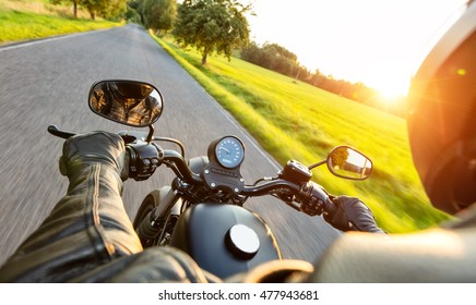 Motorcycle Driver Riding On Motorway In Beautiful Sunset Light. Shot From Pillion Driver View