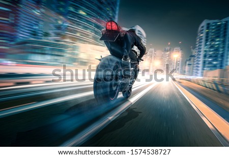 Motorcycle drives through a city at night