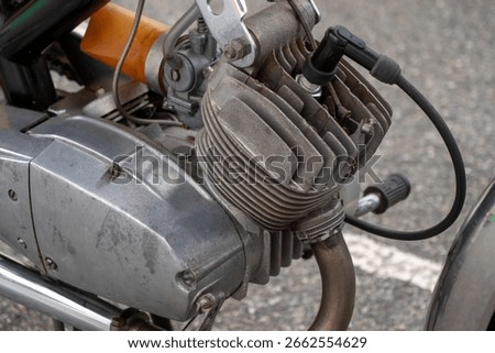 Motorcycle engine.Engine is black and silver, and it is old and worn
