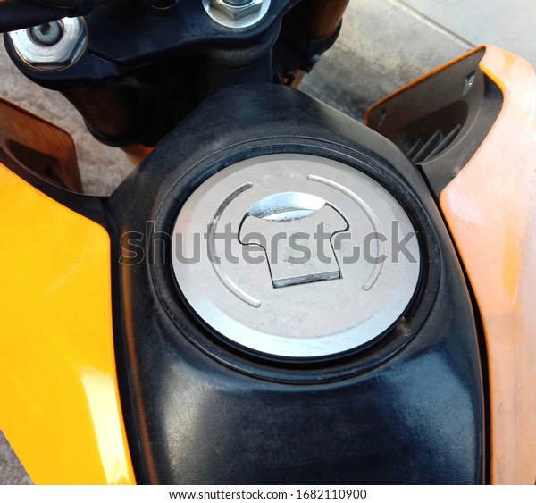 Motorcycle fuel oil tank cap on cement floor\
background closeup.
