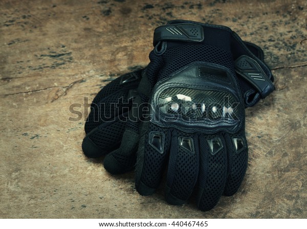 Motorcycle gloves on wooden background,with copy\
space -Vintage effect\
style.