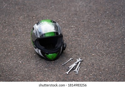 Motorcycle helmet at ground and some wrenches. Wrench at ground