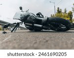 The motorcycle lies on the sidewalk after a ride. Serious accident. Accident, close-up. Lost control and fell. Driving hazards. Collisions with another vehicle.