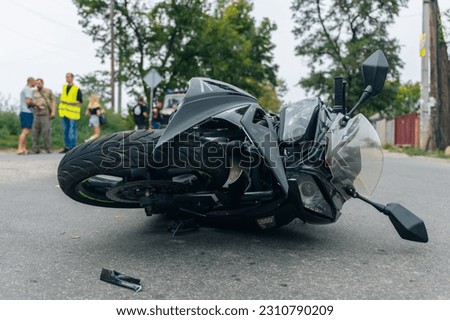 The motorcycle lies on the sidewalk after a road trip. Severe accident. Accident, close-up.