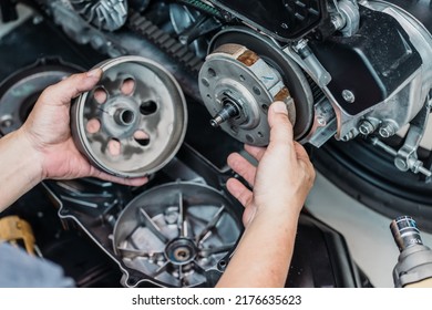 Motorcycle mechanic check the condition of Auto Transmission system or Clutch system of scooter at garage, repair and maintenance motorcycle concept.selective focus - Shutterstock ID 2176635623