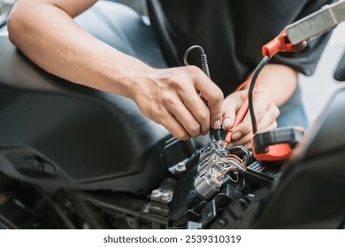 Motorcycle mechanic check motorcycle electrical system  find wiring problems using a multimeter. work in garage, motorcycle repair concept ,  - Powered by Shutterstock