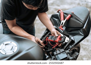 Motorcycle mechanic check motorcycle electrical system,find wiring problems using a multimeter.at garage, motorcycle repair concept - Powered by Shutterstock