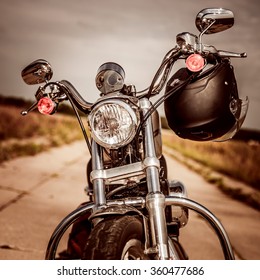 Motorcycle On The Road With A Helmet On The Handlebars.