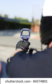 A Motorcycle Police Officer Aiming His Radar Gun A Traffic.