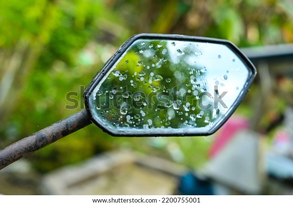 Motorcycle rearview\
mirror wet in the\
rain