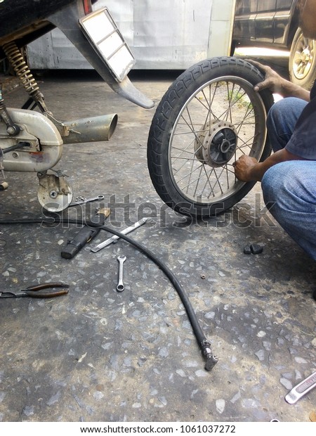 Motorcycle repairman is working to change tires.\
Motorcycle Wheel ,Maintenance,Repair,Car repair shop change,Change\
wheel