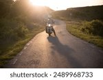 Motorcycle rider on the road in sunset light. Travel and sport, speed and freedom concept