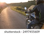 Motorcycle rider on the road in sunset light. Travel and sport, speed and freedom concept