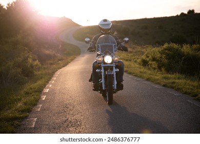 Motorcycle rider on the road in sunset light. Travel and sport, speed and freedom concept