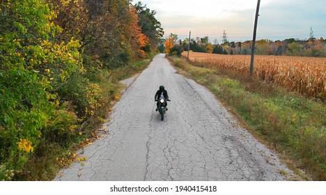 Motorcycle Riding Down A Back-country Road In The Fall Towards Camera (drone)