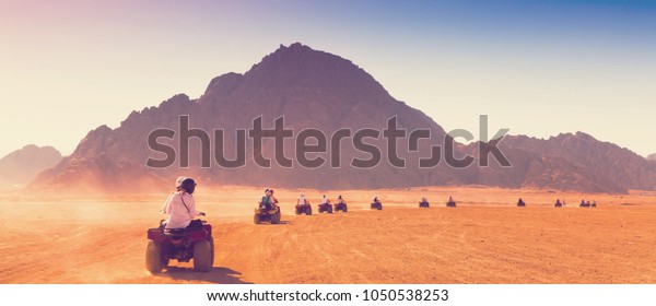 Motorcycle safari in sand desert Egypt. People\
riding travel. Beautiful holiday landscape. Extreme hobby games. \
Transport panorama. Amazing desert Sharm. Adventure Africa. Fun\
game.
