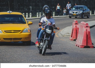 Motorcycle Taxi In Cartagena, Colombia. Motorbike Driver Driving With A Customer As Pillion Between Busy Traffic