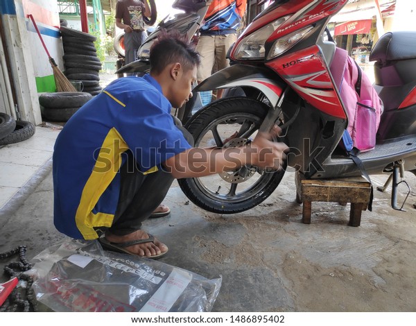 Motorcycle technician when changing front tires with\
new ones, done with care and precision, Trunk / Central Java\
Indonesia, 24 August\
2019