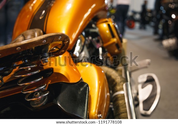 Motorcycle with vintage, leather seat. Close-up seat\
and wheel of bike. Traveling concept. Vintage Motorcycle detail on\
brown seat