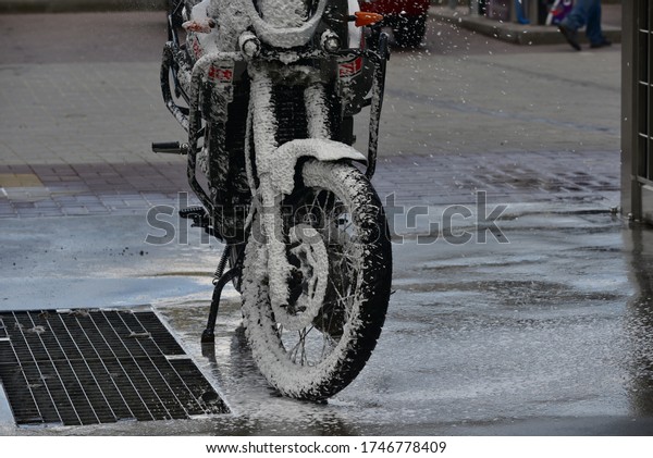 Motorcycle washing with cleaning foam. Pure\
moto bike. Enduro motorcycle. Cleanliness of vehicles. Car wash\
professional. Transportation concept. Vehicle wash. A series of\
photos of a\
motorcycle.