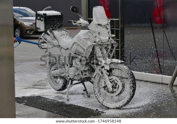 Motorcycle washing with cleaning foam. Pure\
moto bike. Enduro motorcycle. Cleanliness of vehicles. Car wash\
professional. Transportation concept. Vehicle wash. A series of\
photos of a\
motorcycle.