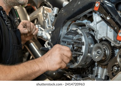 Motorcycle workshop with mechanics repairing an engine - Powered by Shutterstock