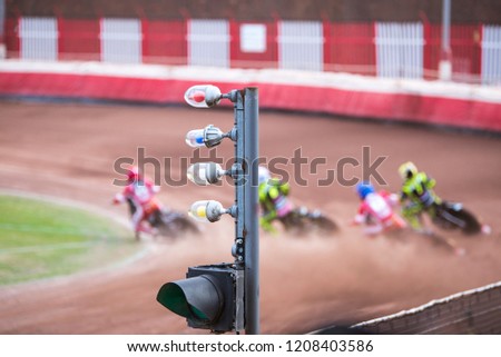 Motorcycles speedway race, four motorbikes in the curve, focus on foreground