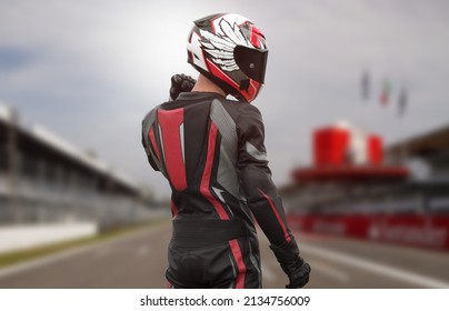 Motorcyclist in full gear and helmet on the race track.