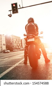 motorcyclist on the road with the setting sun