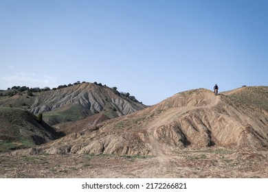 Motorcyclist Riding Pit Bike Enduro Motorcycle Over The Hills Of Canyon Mountains