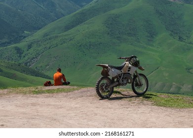 The motorcyclist is sitting on the side of the road in the mountains. Motorcycle travel.