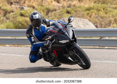 motorcyclist taking a sharp curve on his bike. Photograph taken in the port of Navalmoral, province of the city of Avila, Spain, during the day September 9, 2020