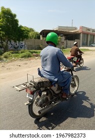 A motorcyclist travelling on a road wearing a helmet   - Karachi Pakistan - may 2021