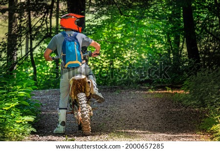 motorcyclist while driving in the woods, enduro or motocross sport for fun and recreation