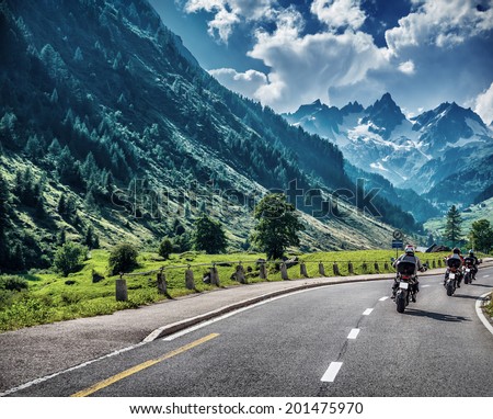 Motorcyclists on mountainous road, enjoying tour along Alps, summertime activities, wonderful mountain landscape, extreme vacation concept