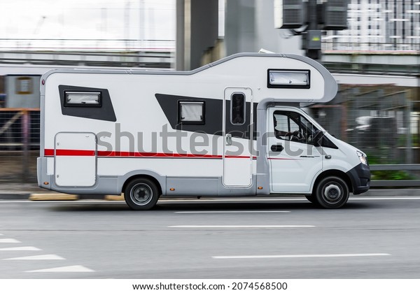 Motorhome, Caravan car\
for trip or vacation, driving on the city street. Camper based on\
Gazelle NEXT in motion on the urban road. Recreational Vehicle for\
travel