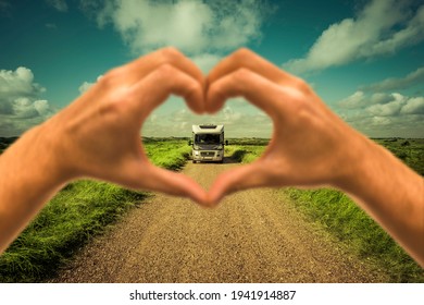 Motorhome on a dust road seen through a blurred heart hand - Shutterstock ID 1941914887
