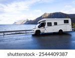 A motorhome parked by the road in the autumn landscape of Senja Island, Norway, with fjords and mountains.