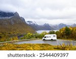 A motorhome parked by the road in the autumn landscape of Senja Island, Norway, with fjords and mountains.